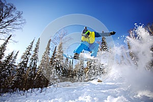 Snowboarder jumping from the springboard against the sky