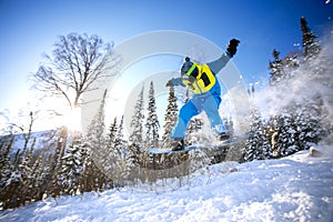 Snowboarder jumping from the springboard against the sky