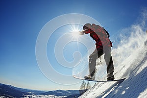 Snowboarder jumping from the springboard against the sky