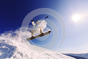 Snowboarder jumping from the springboard against the sky