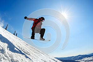 Snowboarder jumping from the springboard against the sky