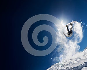 Snowboarder making high jump in clear blue sky photo