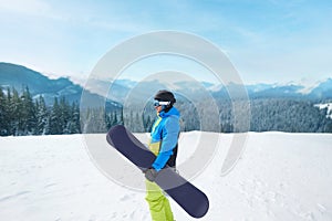 Snowboarder Of Man At Ski Resort On The Background Blue Sky,  Hold Snowboard. Wearing Ski Glasses.