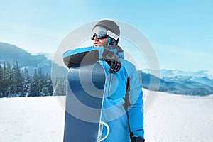 Snowboarder Of Man At Ski Resort On The Background Blue Sky,  Hold Snowboard. Wearing Ski Glasses. Ski Goggles  With The Reflectio