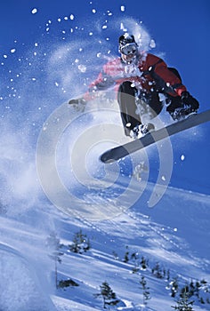 Snowboarder In Midair With Snow Powder Trailing Behind