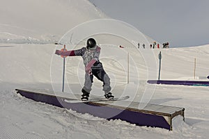 Snowboarder in the park on a box. Snow park box tricks. Winter jibbing in snwopark in France
