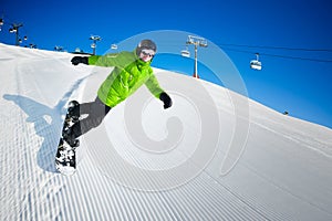 Snowboarder on piste in high mountains