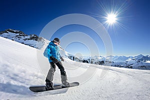 Snowboarder on piste in high mountains