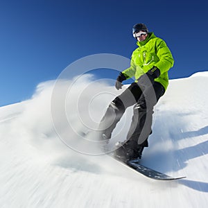 Snowboarder on piste in high mountains