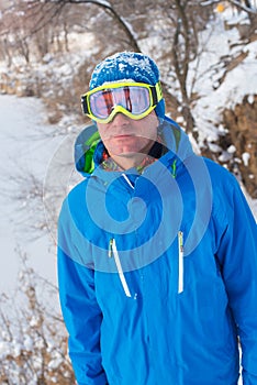 A snowboarder resting at a ski resort.