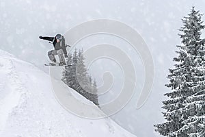 Snowboarder rides from powder snow hill. Mountain freeride snowboarding. Winter Carpathians