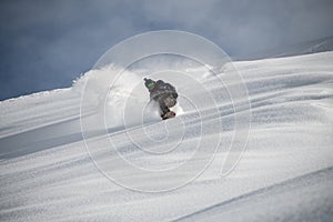 Snowboarder riding down the mountain side covered in snow