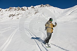 snowboarder riding freeride on snow down the slope against the backdrop of the mountains