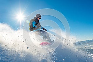 Snowboarder Riding Red Snowboard in Mountains at Sunny Day. Snowboarding and Winter Sports photo