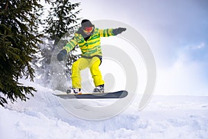 Snowboarder Riding Snowboard in the Forest at Cloudy Day. Snowboarding and Winter Sports