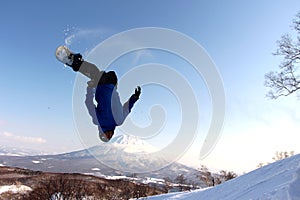 Snowboarder sending it off backcountry jump photo