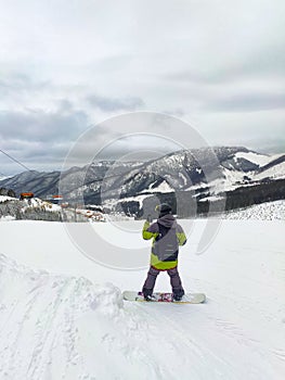 Snowboardista na zjazdovke hory krajina na pozadí