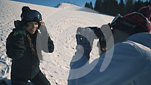 Snowboarder or skier and photographer make photo session on ski resort mid shot