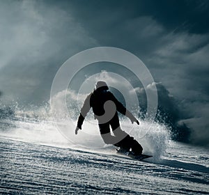 Snowboarder slides down the snowy hill