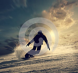 Snowboarder slides down the snowy hill