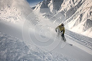 Snowboarder slipping down the mountain through the snow