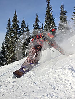 A snowboarder in the snow. A young man is a snowboarder running down a slope. Winter sports and recreation, outdoor