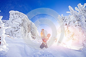 Snowboarder with snowboard background blue sky with sun light frozen rocks, Sheregesh ski resort. Concept extream