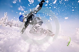 Snowboarder on snowboard rides through snow, explosion. Freeride in winter Ski Resort.