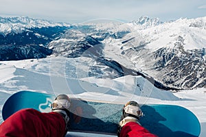 Snowboarder with snowboard is sitting on the mountain