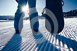 Snowboarder with snowboard stand on ski piste