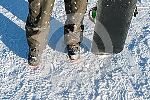 Snowboarder with snowboard stand on ski piste in winter