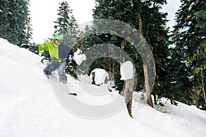 Snowboarder with special equipment is riding and jumping very fast in the mountain forest