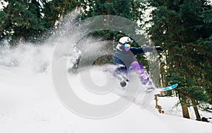 Snowboarder with special equipment is riding and jumping very fast in the mountain forest