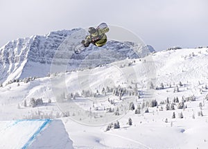 Snowboarder spinning doing a grab in the air