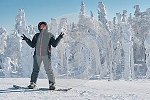 Snowboarder staing on a background of white snowy forest