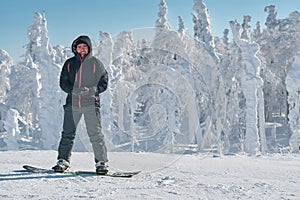 Snowboarder staing on a background of white snowy forest