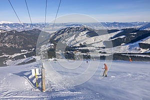 Snowboardista na slunečné sjezdovce se zasněženou vánicí a panoramatem hor