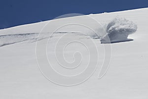 Snowboarder turning on fresh powder snow creating a snow wave