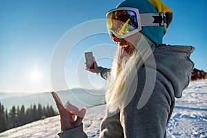Snowboarder using smart phone in the mountains