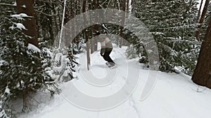 The snowboarder very quickly descends along a forest track