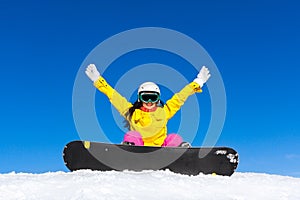 Snowboarder woman sitting on snow mountain slope