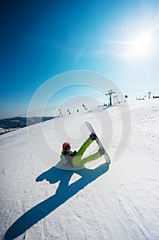 Snowboarder in yellow clothes resting on the mountain