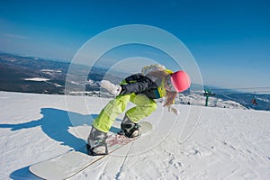 Snowboarder in yellow clothes resting on the mountain