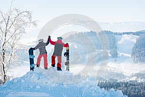 Snowboarders couple standing on top of the mountain
