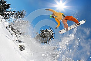 Snowboarders jumping against blue sky