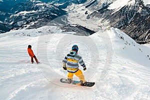 Snowboarders is riding down of mountain