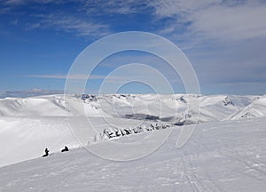 Snowboarders on the top of the winter mountains