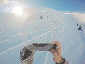 Snowboarding freeride winter, along man with board in mountains selfie with phone