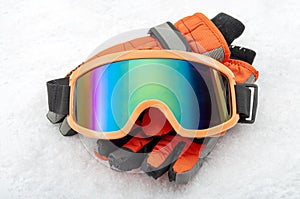 Snowboarding and skiing protective gear and winter extreme sports concept with ski goggles and cold weather gloves  on