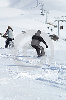 Snowborder and biker downhill